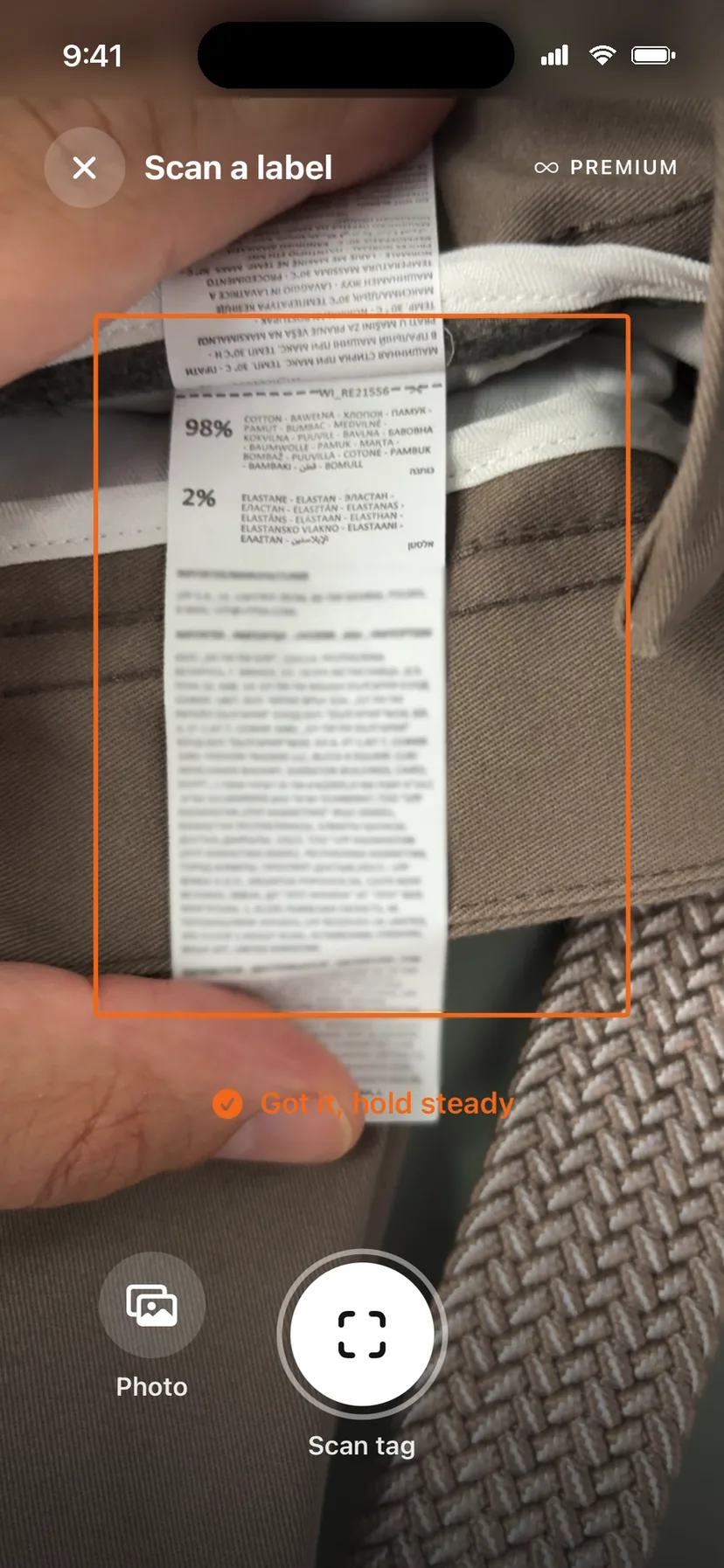 ClothTrace scanner reading a real sewn-in care label: 98% cotton, 2% elastane, got it, hold steady